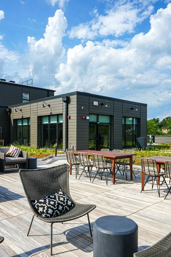A black chair with a white and black pillow is in front of a building.